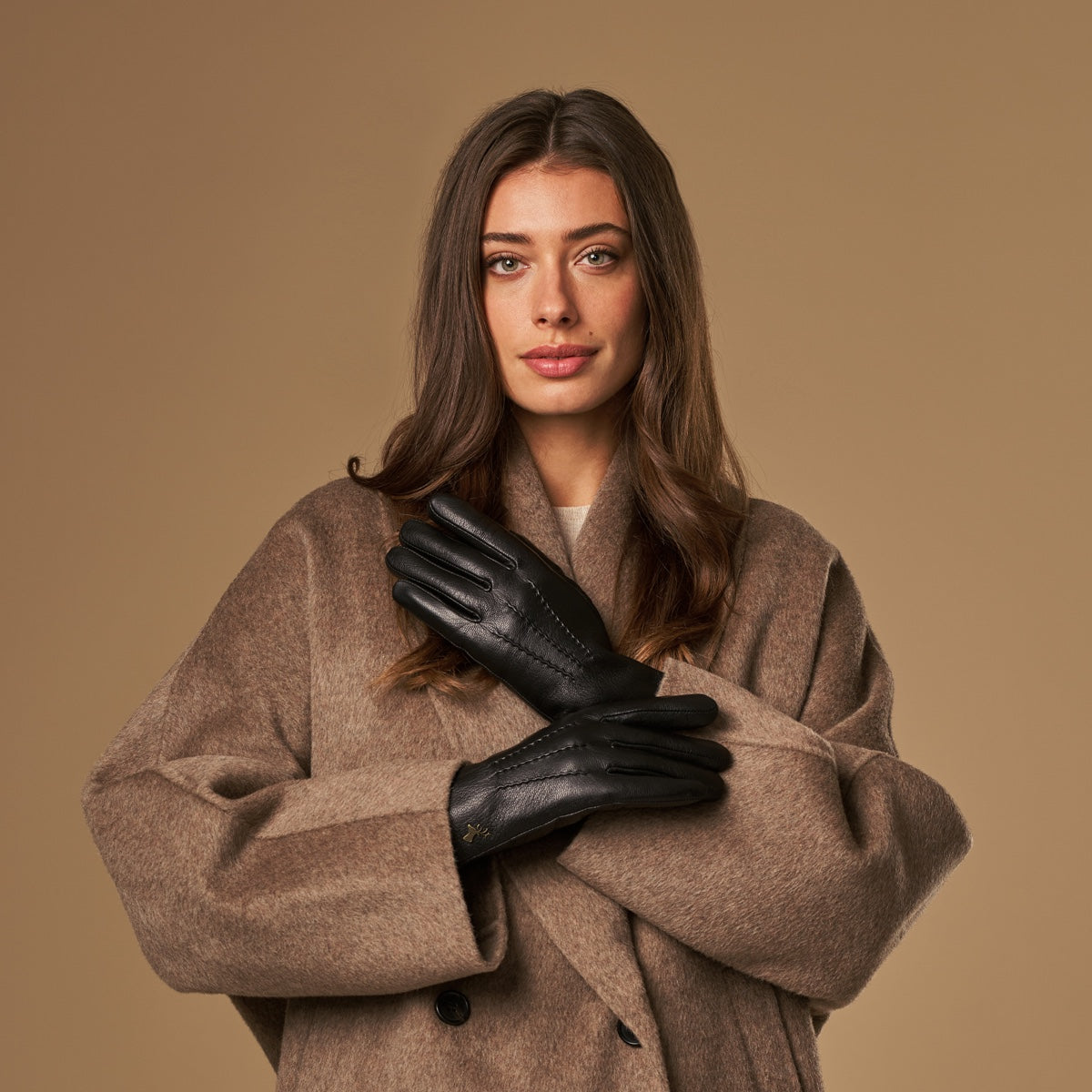 Black leather gloves with lambswool lining worn with a tan wool coat