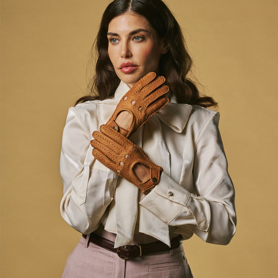 Women’s cognac leather driving gloves with buttoned wrist strap and perforated fingers