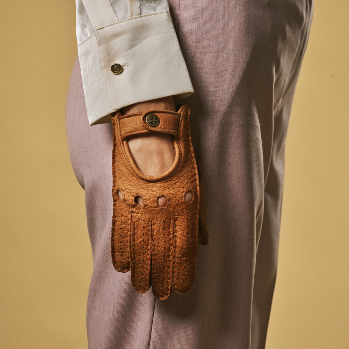 Cognac peccary leather driving glove with stitched finger grooves and snap wrist