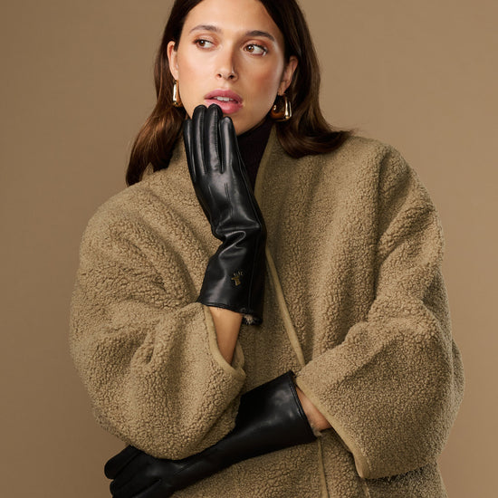 Black leather gloves with long cuffs and fur lining, touchscreen detail at palm
