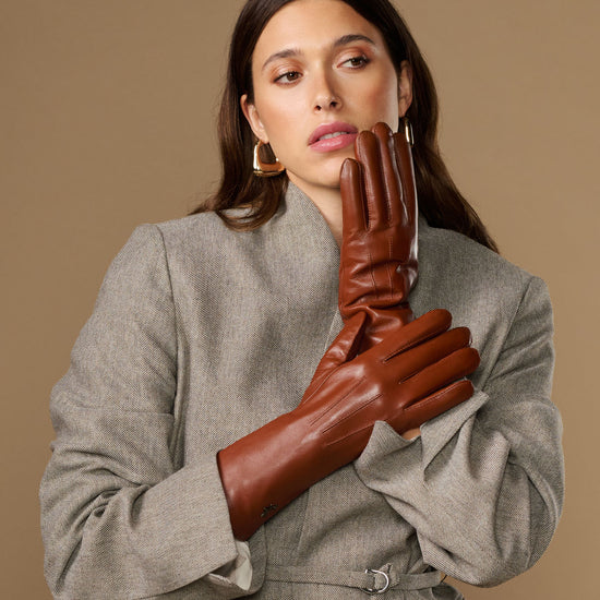 Pair of extra-long cognac leather gloves with rabbit-fur cuffs, worn close-up