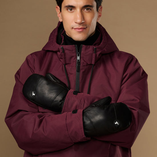 Black leather men's mittens worn crossed over the chest.