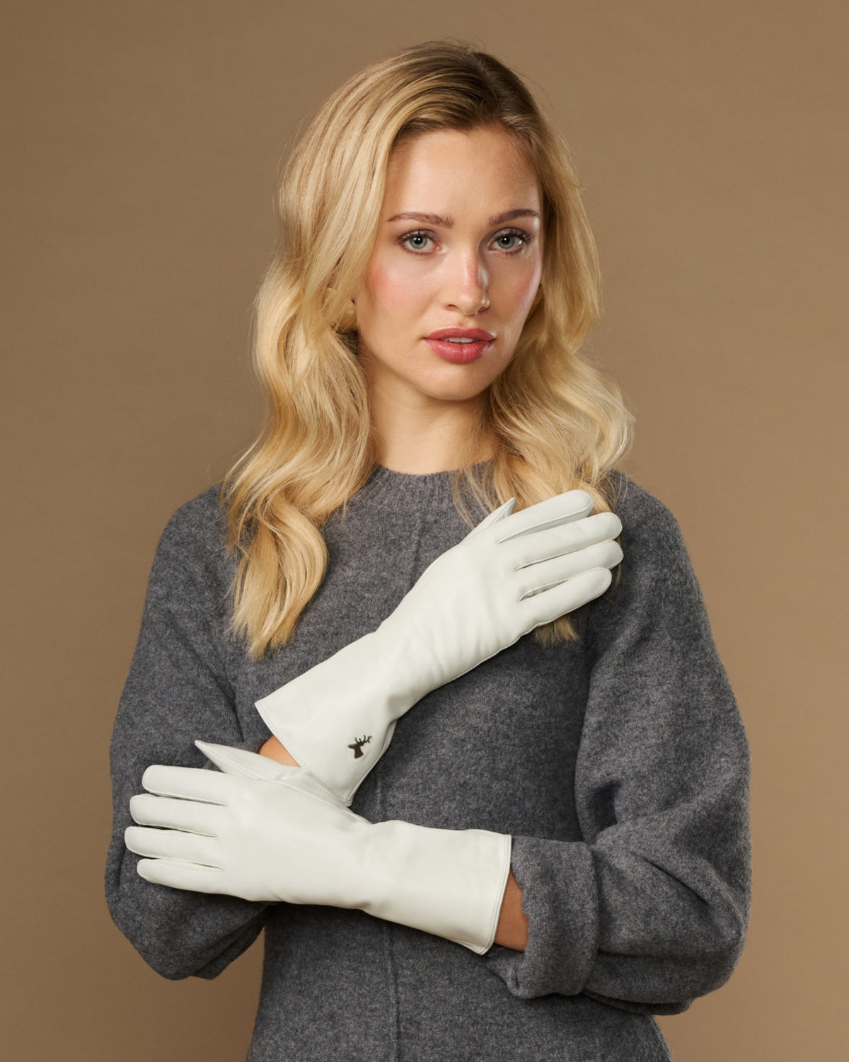 White long leather gloves worn, cuffs at wrists with stitched, clean design