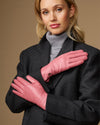 Women’s pink leather gloves with stitched fingers and small logo on back of hand