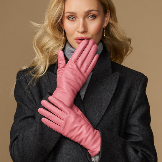 Women’s pink leather gloves held together, showing smooth back and stitched fingers