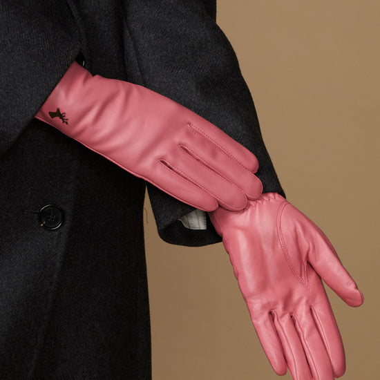 Women’s pink leather glove detail with stitched seams and small logo on wrist