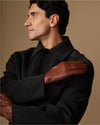 Cognac leather glove over hand with fleece-lined cuff, worn on forearm