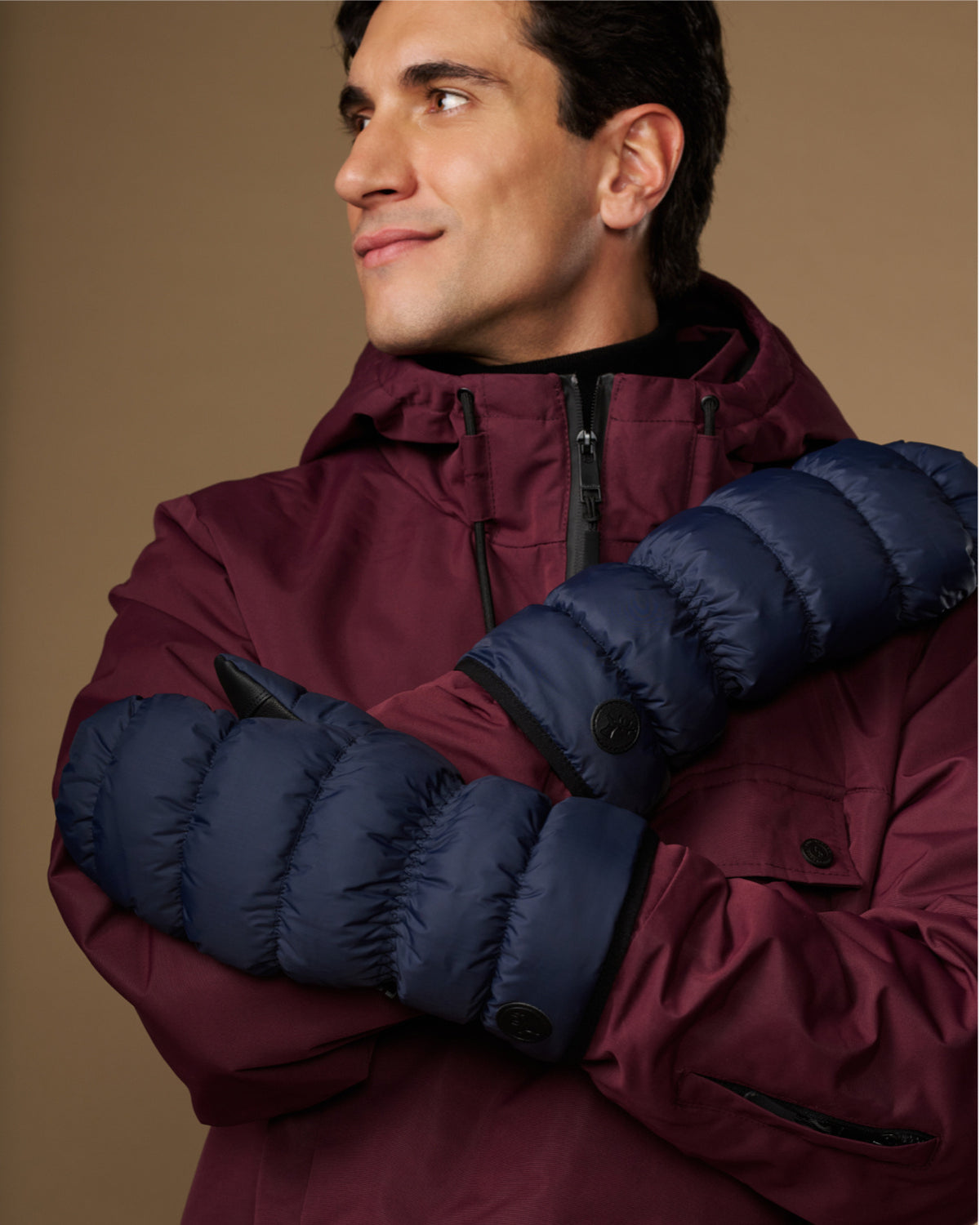 Blue padded mittens with logo buttons on the back of the hand
