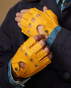 Yellow fingerless lambskin driving gloves with perforated panels and snap strap