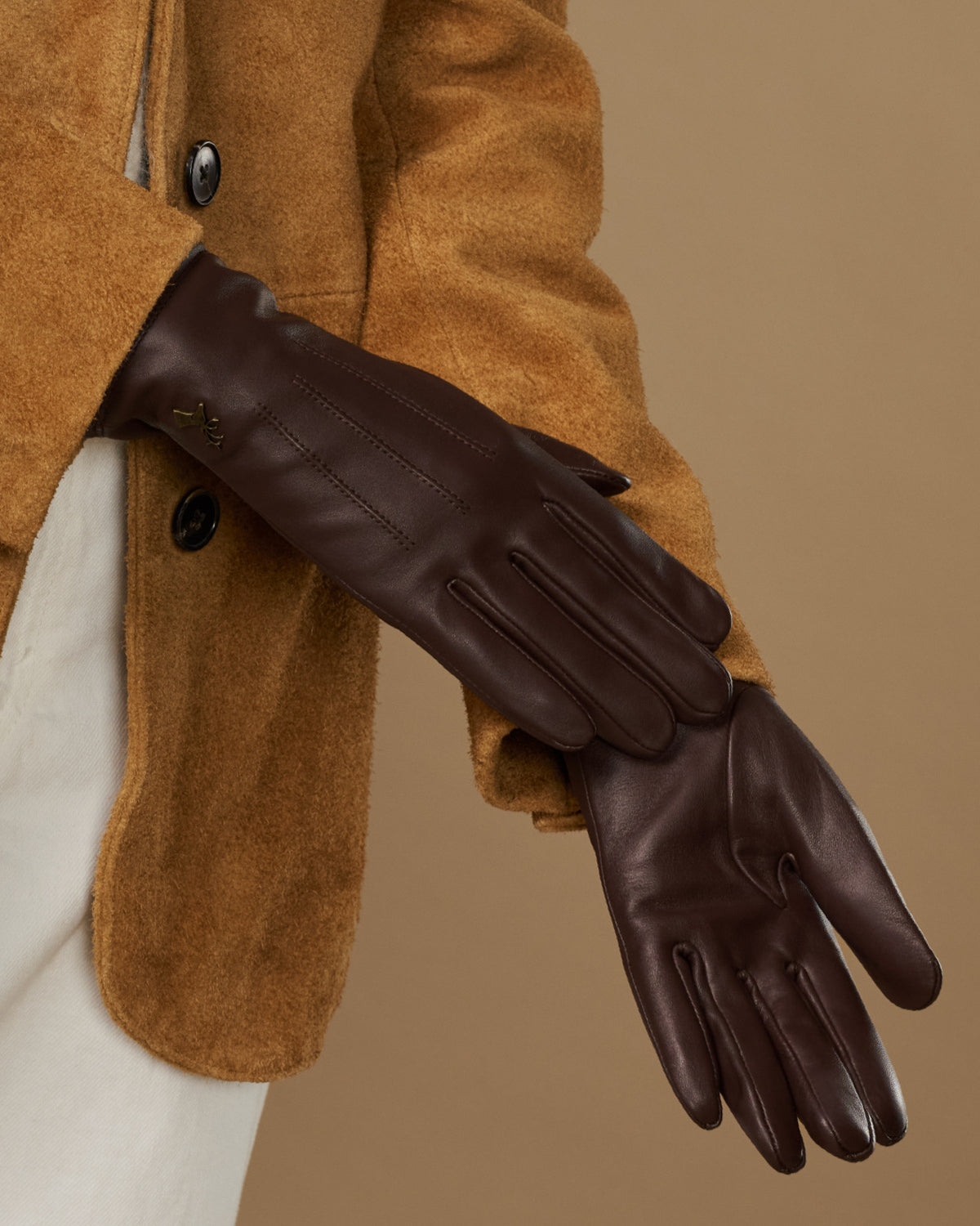 Brown leather gloves with fleece lining, close-up side view of one glove