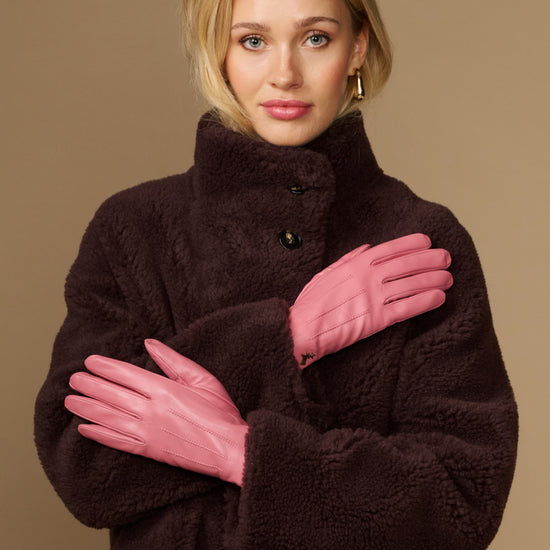 Pink leather gloves with dark fleece lining, buttoned cuff detail