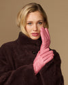 Pink leather gloves with dark fleece lining, hands held near face