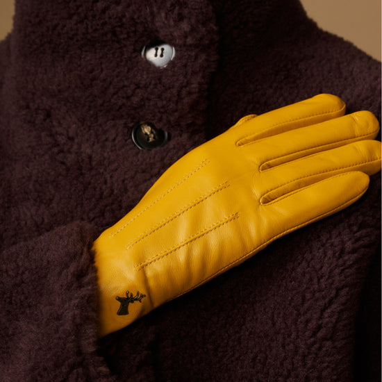 Yellow leather glove detail with stitched paneling and dark fleece collar