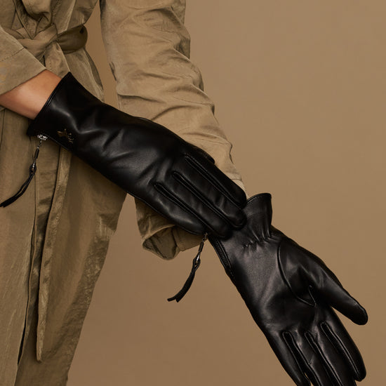 Black leather gloves with side zipper and wrist ties, angled close-up