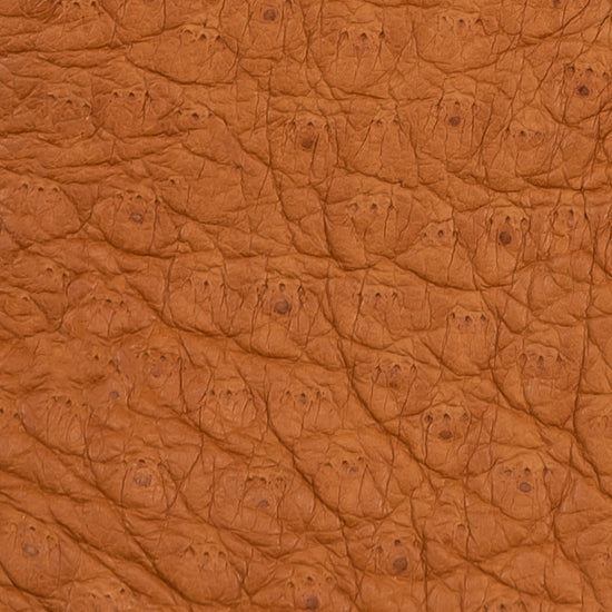 Close-up of cognac brown peccary leather texture with fine pebbled pattern