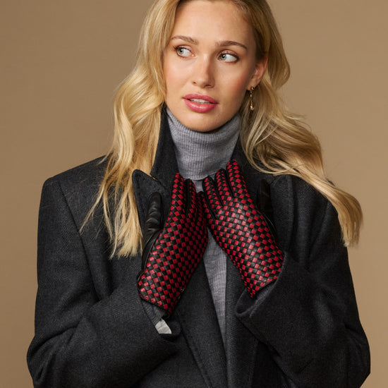 Women's black leather gloves with red-and-black checkered lining, arms crossed