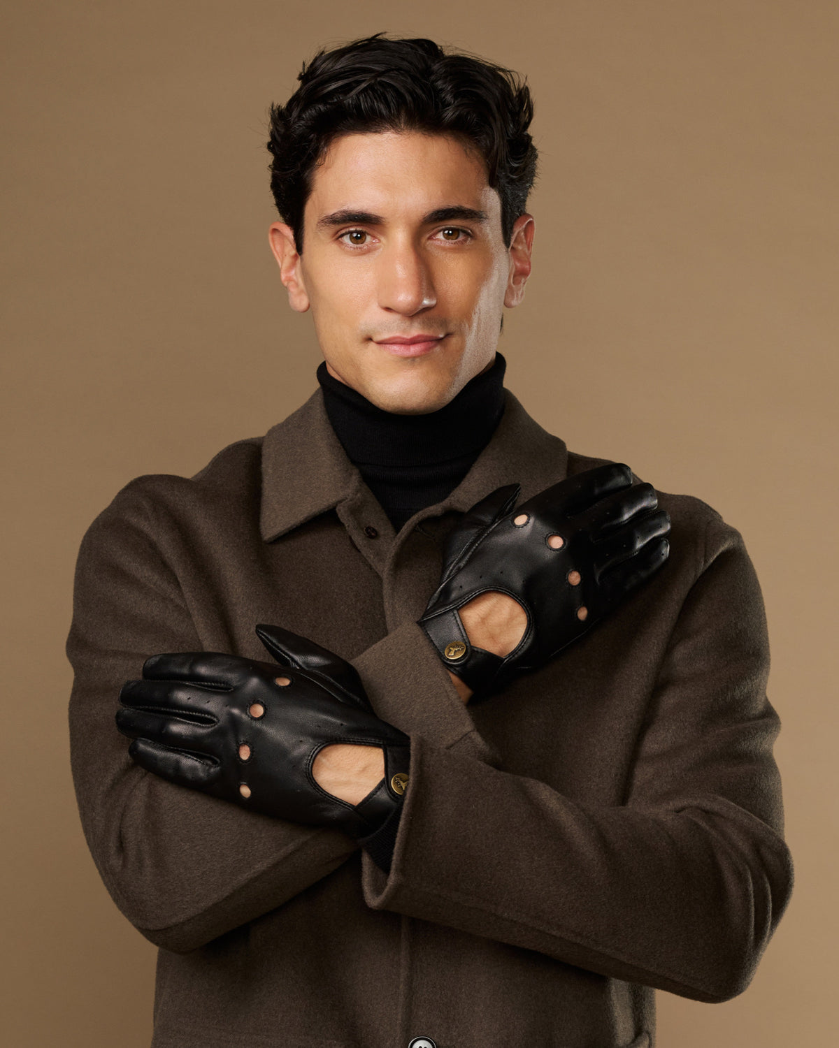 Men's black leather driving gloves with touchscreen fingers and elastic wrist cuffs