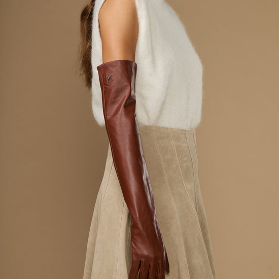Chestnut brown leather opera glove on arm, long sleeve with fitted wrist cuff