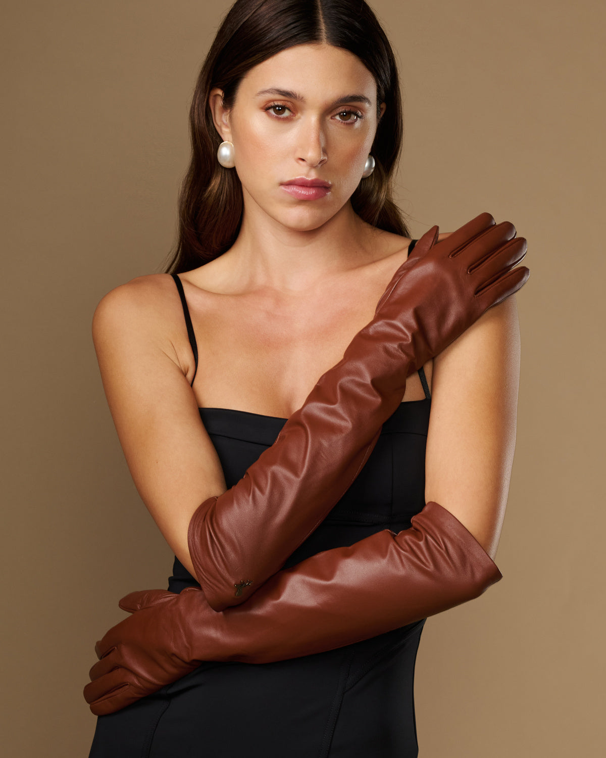 Chocolate brown leather elbow gloves worn close-up showing wrinkle-free texture