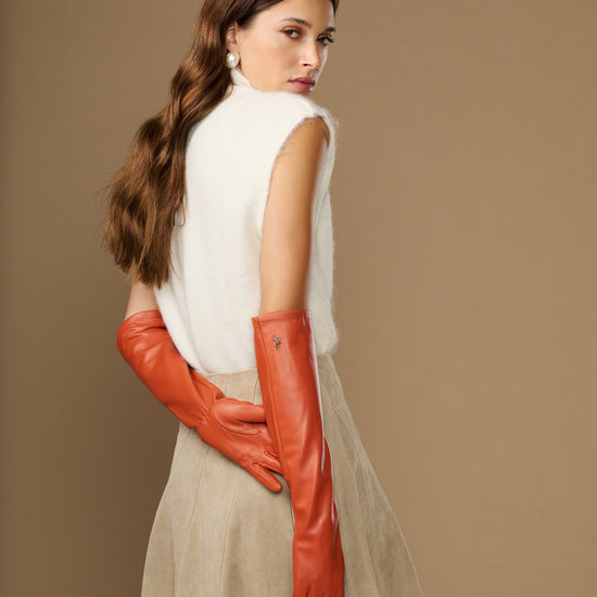 Orange leather elbow gloves shown from the side with long, fitted forearm coverage