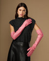 Women's pink leather gloves with long cuffs, hand posed near face