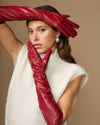 Red leather elbow gloves with long cuff and sleek stitched finger seams