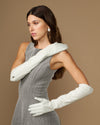 White elbow-length leather gloves with one hand flexed; fitted fingers and cuff