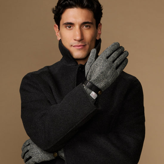Men's classic gloves crossed: dark felt gloves with gray herringbone detail at wrist.