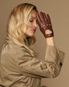 Brown leather driving gloves with perforated fingers and buttoned cuff detail