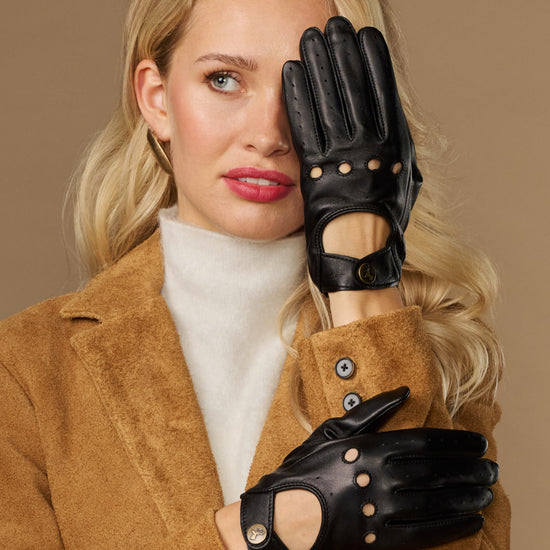 Black leather driving gloves with button details and elastic wrist cuffs, touchscreen-ready.