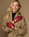 Women’s red leather driving gloves with cutout knuckles and buttoned wrist straps