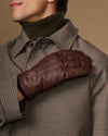 Brown leather glove worn on arm with fleece-lined cuff