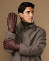 Brown leather gloves worn, one raised for a clear front view
